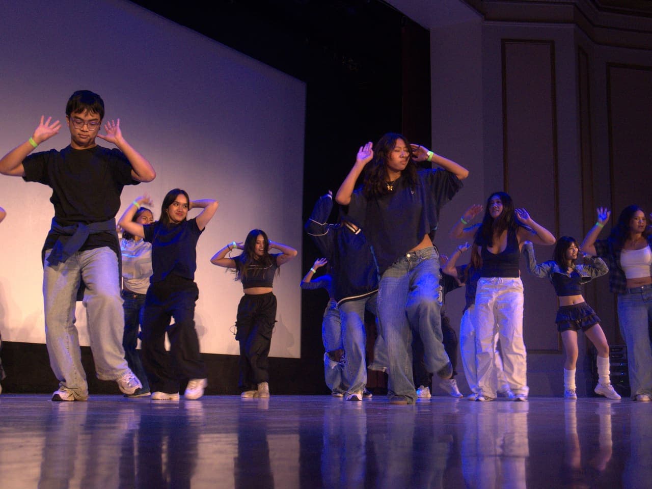 Delegates performing a choreographed dance number on stage
