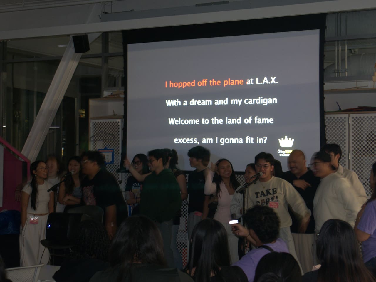 Delegates singing together on stage during a karaoke night