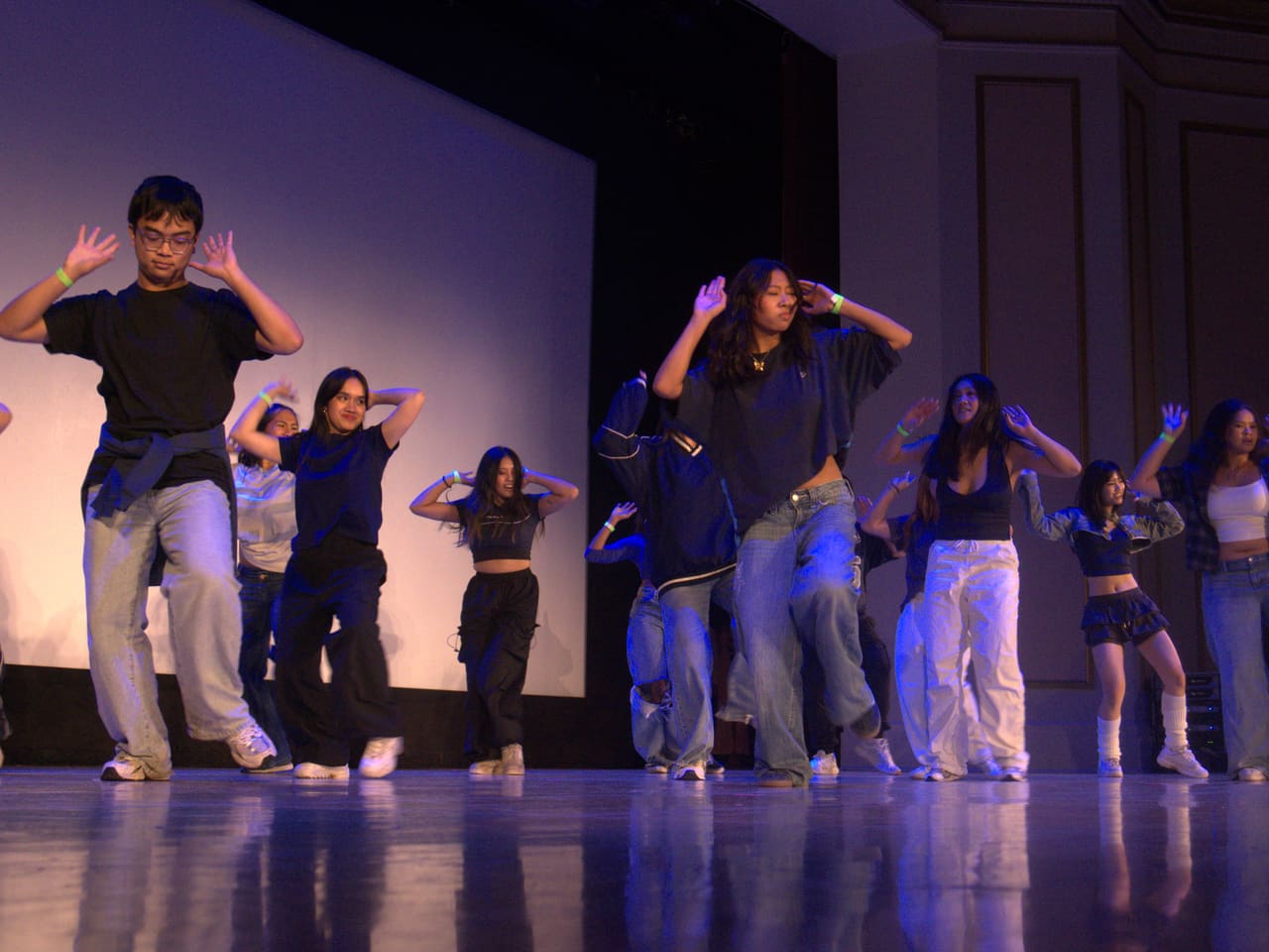 Delegates performing a choreographed dance number on stage